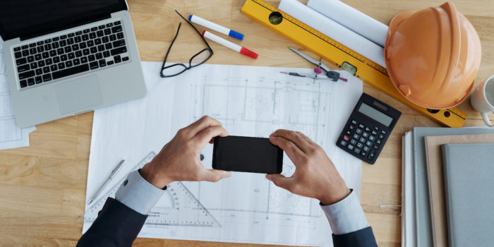 Hands of businessman taking photo of construction plan